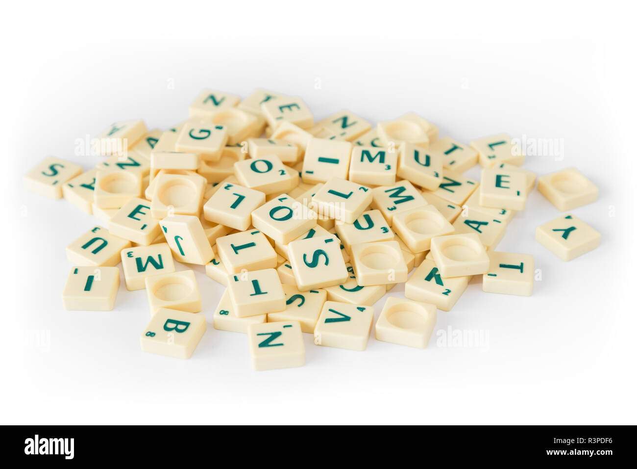 Pile of random Scrabble game letter tiles with score value mixed up, isolated on white background. Stock Photo