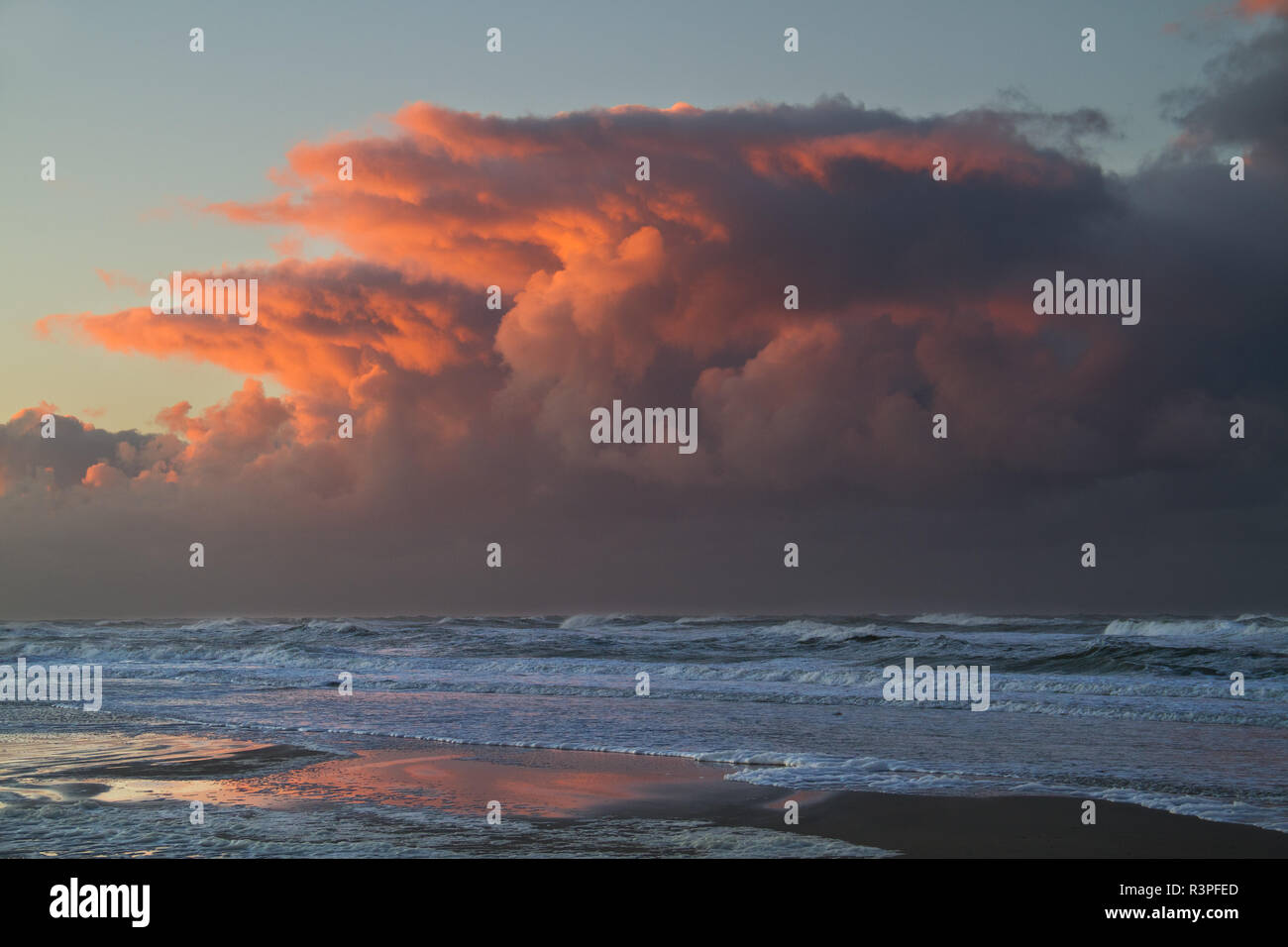 Storm front approaching over the sea after sunset: threatening red clouds above the dark water Stock Photo