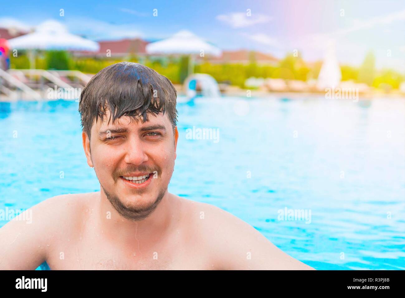 Man swimming in the pool. Young guy looks forward. He is swimming in