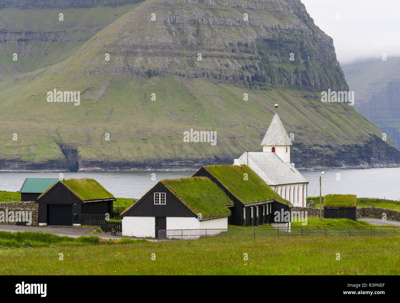 Village Vidareidi with church on the Island Vidoy. View towards Bordoy and Kunoy. Faroe Islands, Denmark Stock Photo