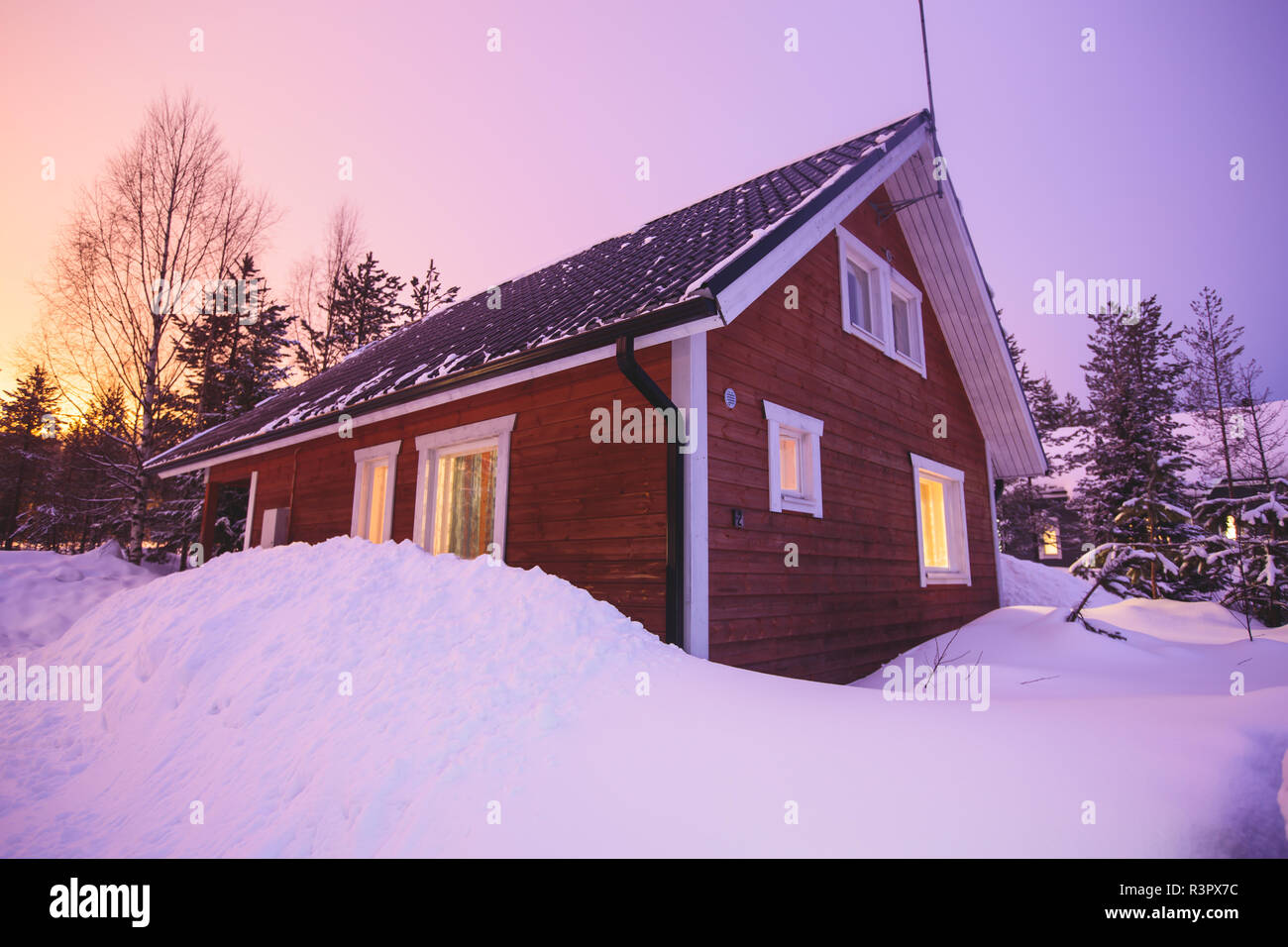 A cozy wooden cabin cottage chalet house covered in snow near ski ...
