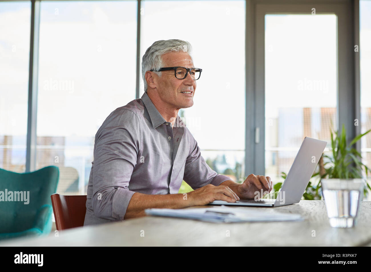 Mature man using laptop on table at home Stock Photo