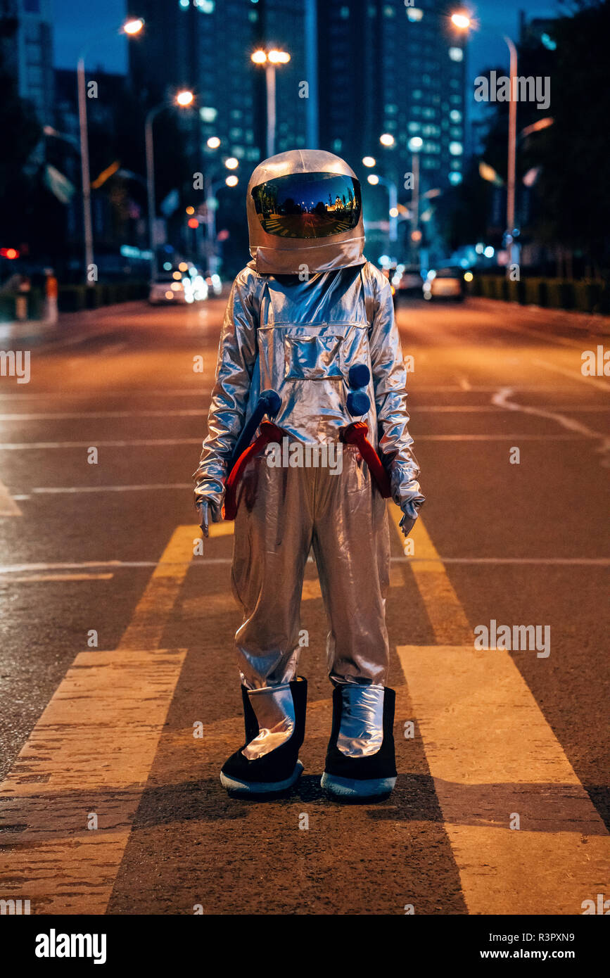 Spaceman standing on a street in the city at night Stock Photo - Alamy