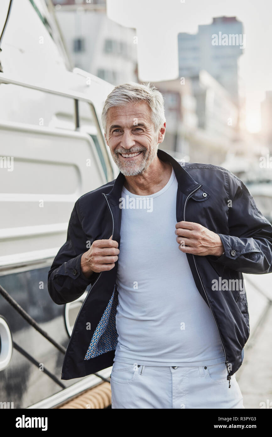 Smiling mature man at a marina next to a yacht Stock Photo - Alamy