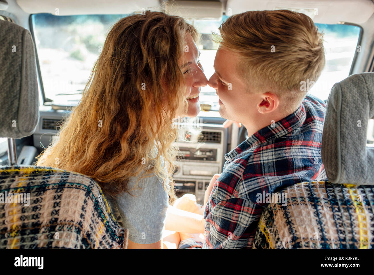 Romantic couple doing road trip, kissing in car Stock Photo