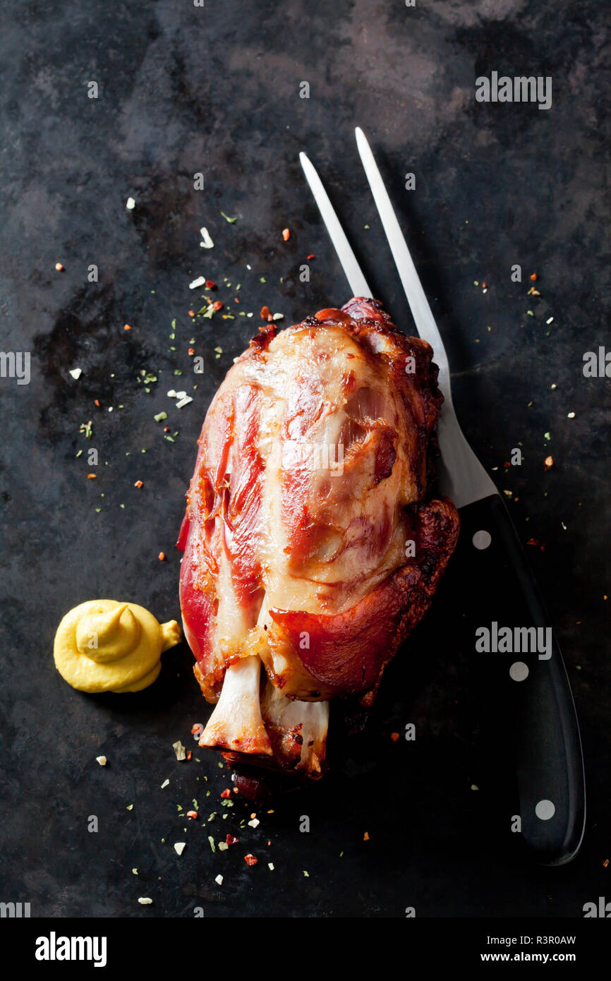 Roasted knuckle of pork with mustard on a baking tray Stock Photo