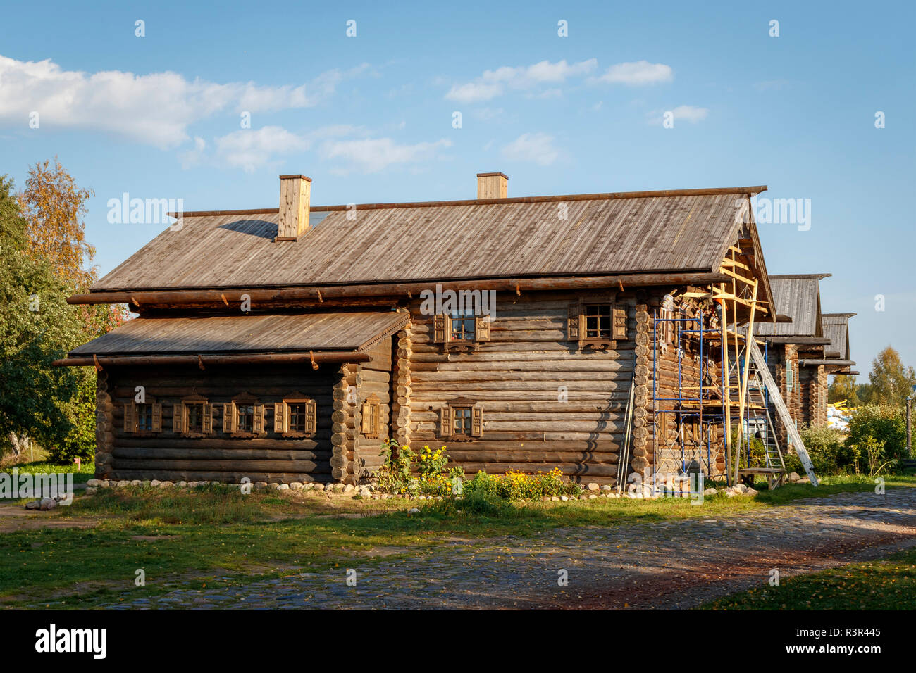 A traditional multi-purpose wooden building undergoes renovation in Verkhniye Mandrogi, Russia. A craft and mueum tourist village on the Svir River. Stock Photo