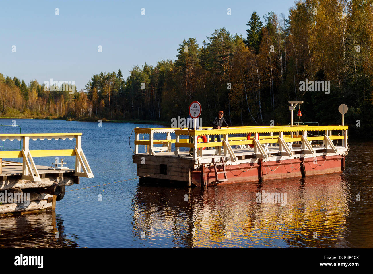 The pull-ferry operating on the Svir River at Verkhniye Mandrogi, Russia. A craft and museum attraction. Stock Photo