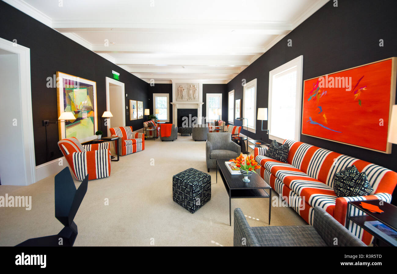 A large living room seating area in a hotel decorated in the color orange Stock Photo