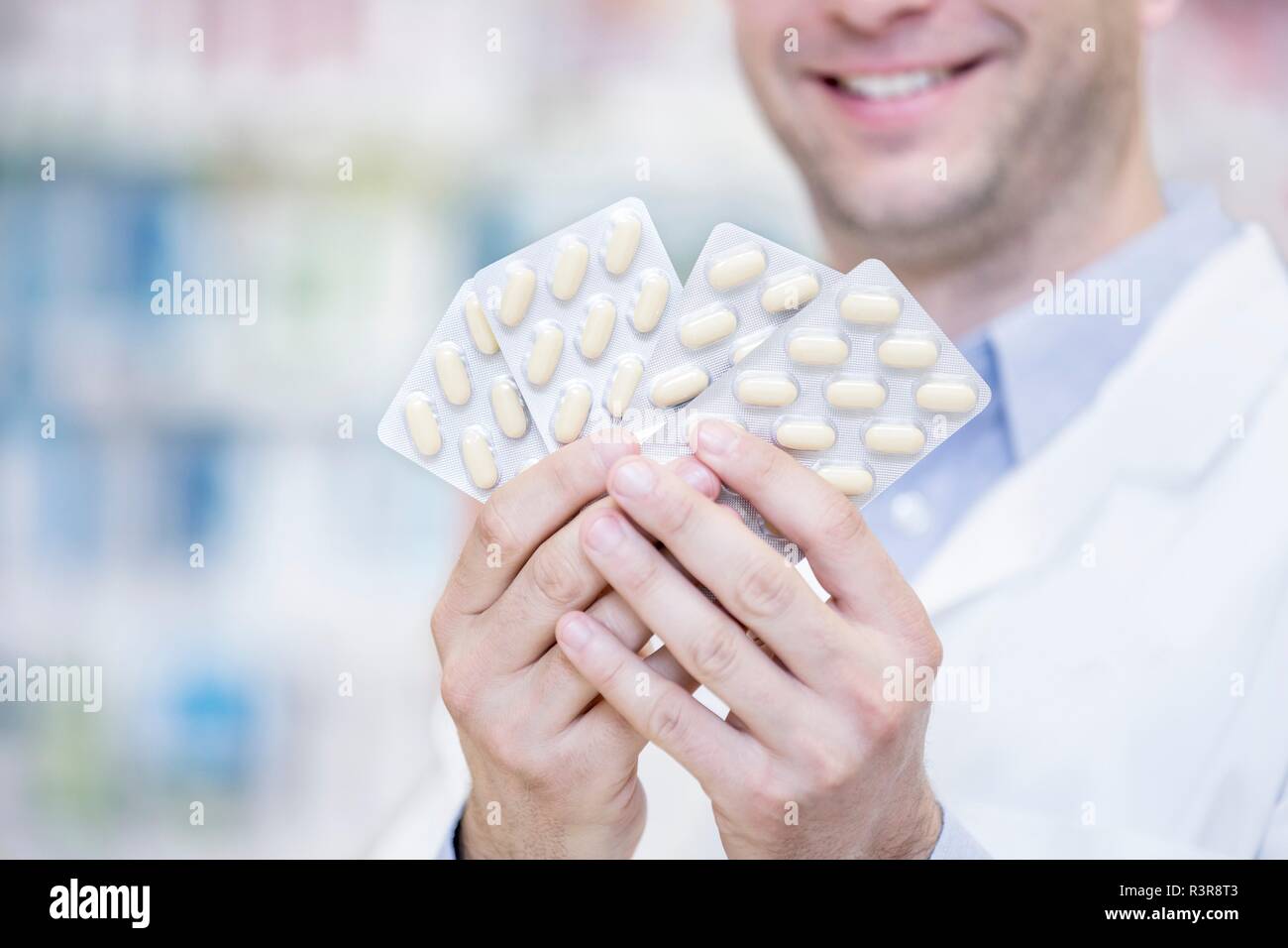 Pharmacist holding blister packs in pharmacy Stock Photo Alamy