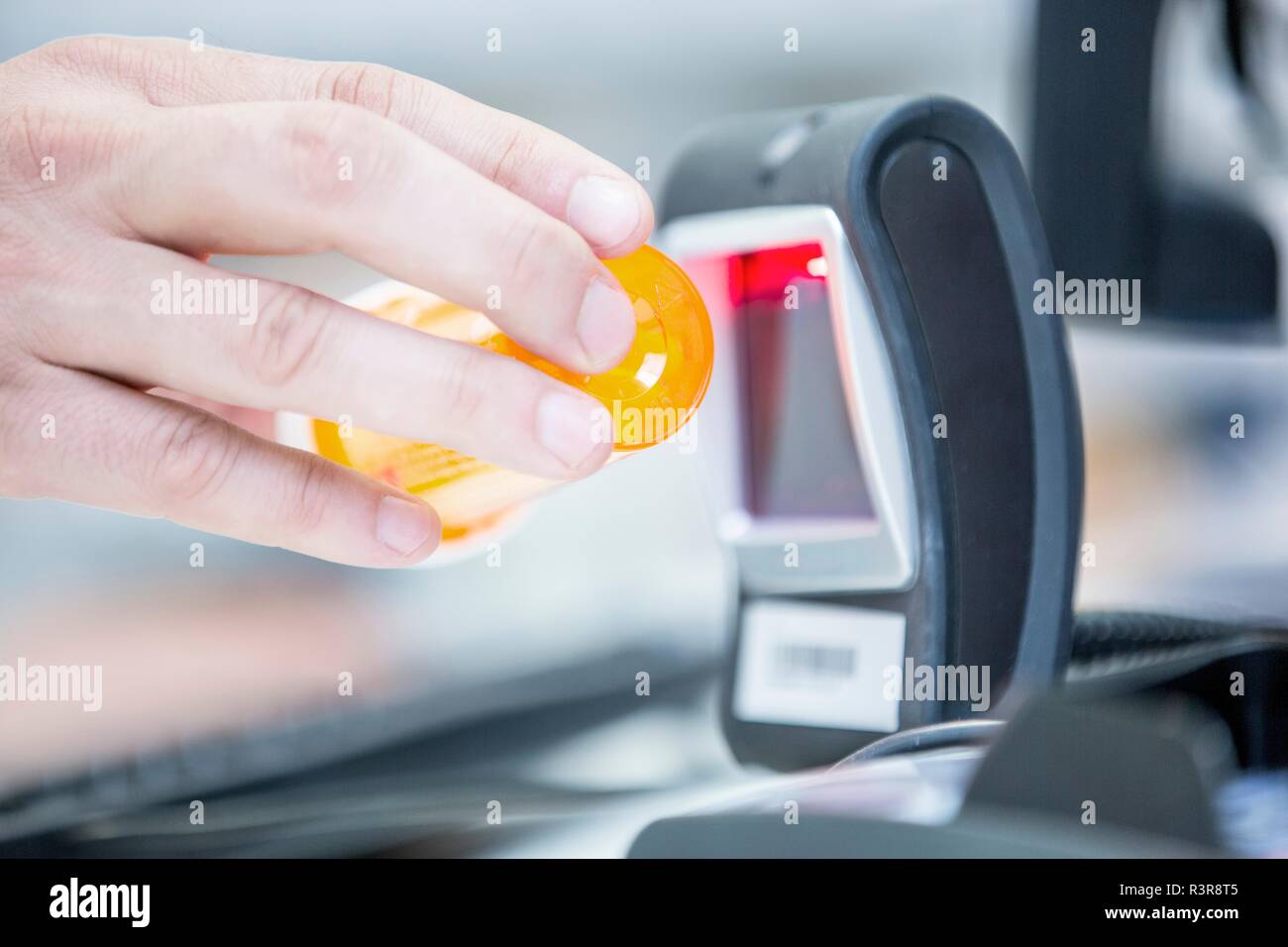 Pharmacist scanning medicine with barcode reader in pharmacy. Stock Photo