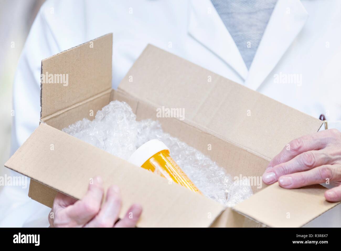 Pharmacist opening box containing medicine. Stock Photo