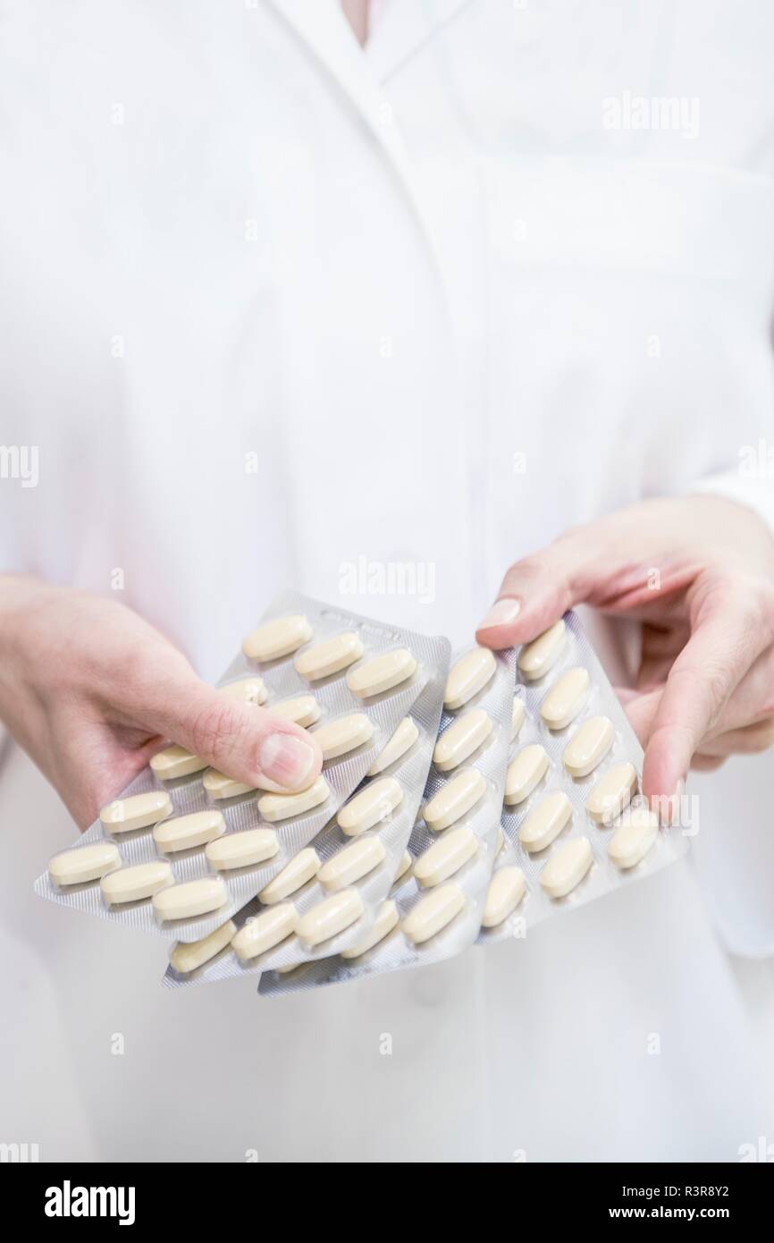 Close-up of pharmacist holding pills in blister packs. Stock Photo