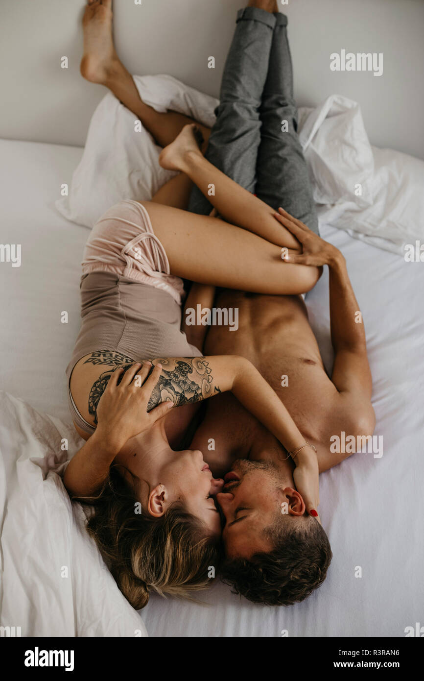 Romantic young couple lying in bed Stock Photo