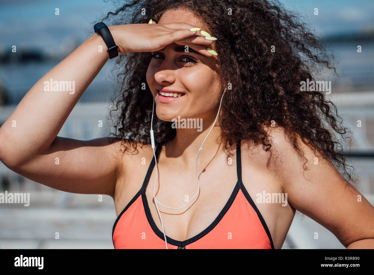 Portrait of smiling young athletic woman wearing bra outdoors Stock Photo