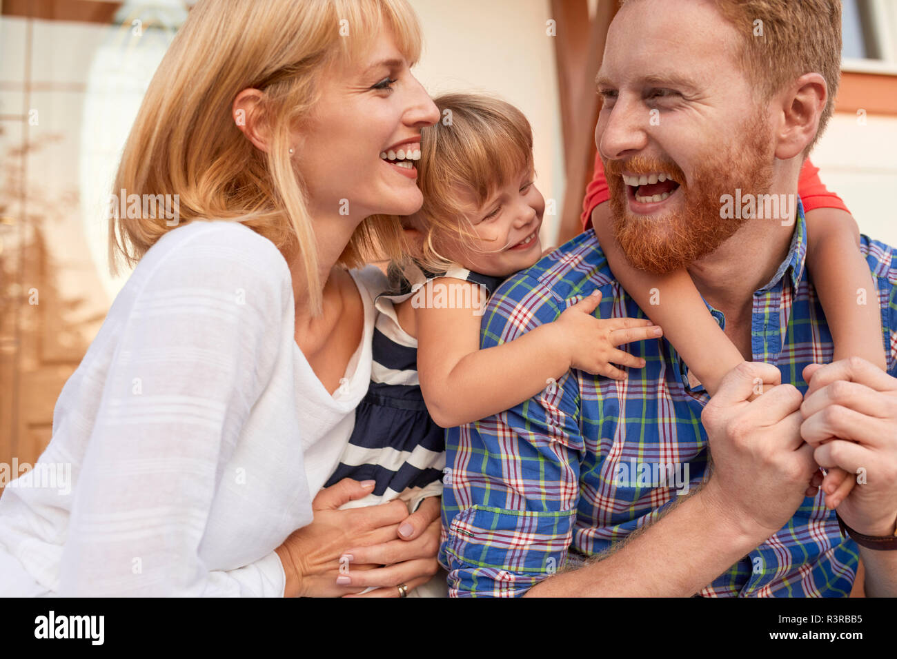 Happy family on porch of their home Stock Photo