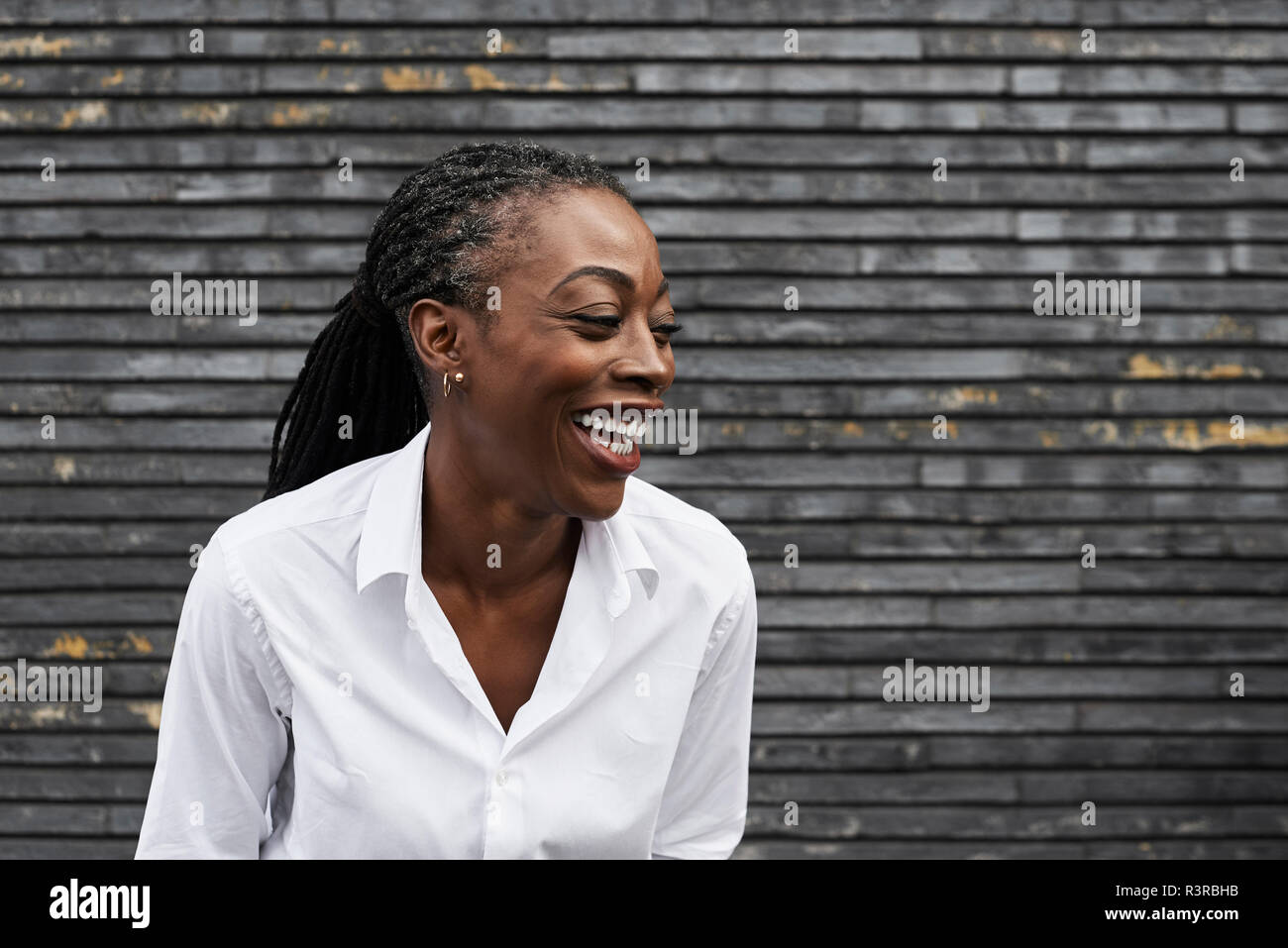 Portrait of laughing businesswoman  wearing white shirt Stock Photo