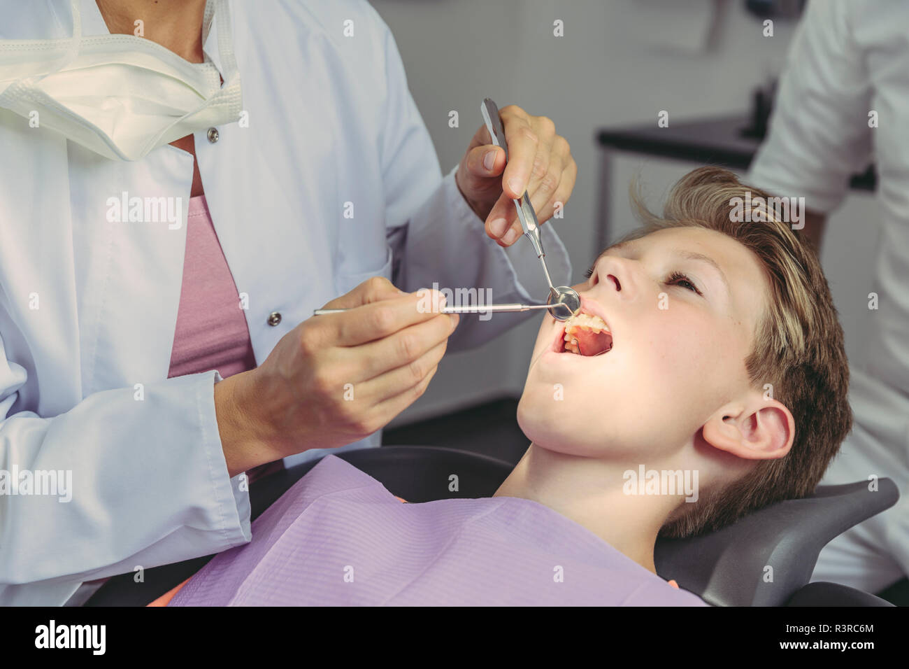 Dentist examining boy's teeth with dental instruments Stock Photo Alamy