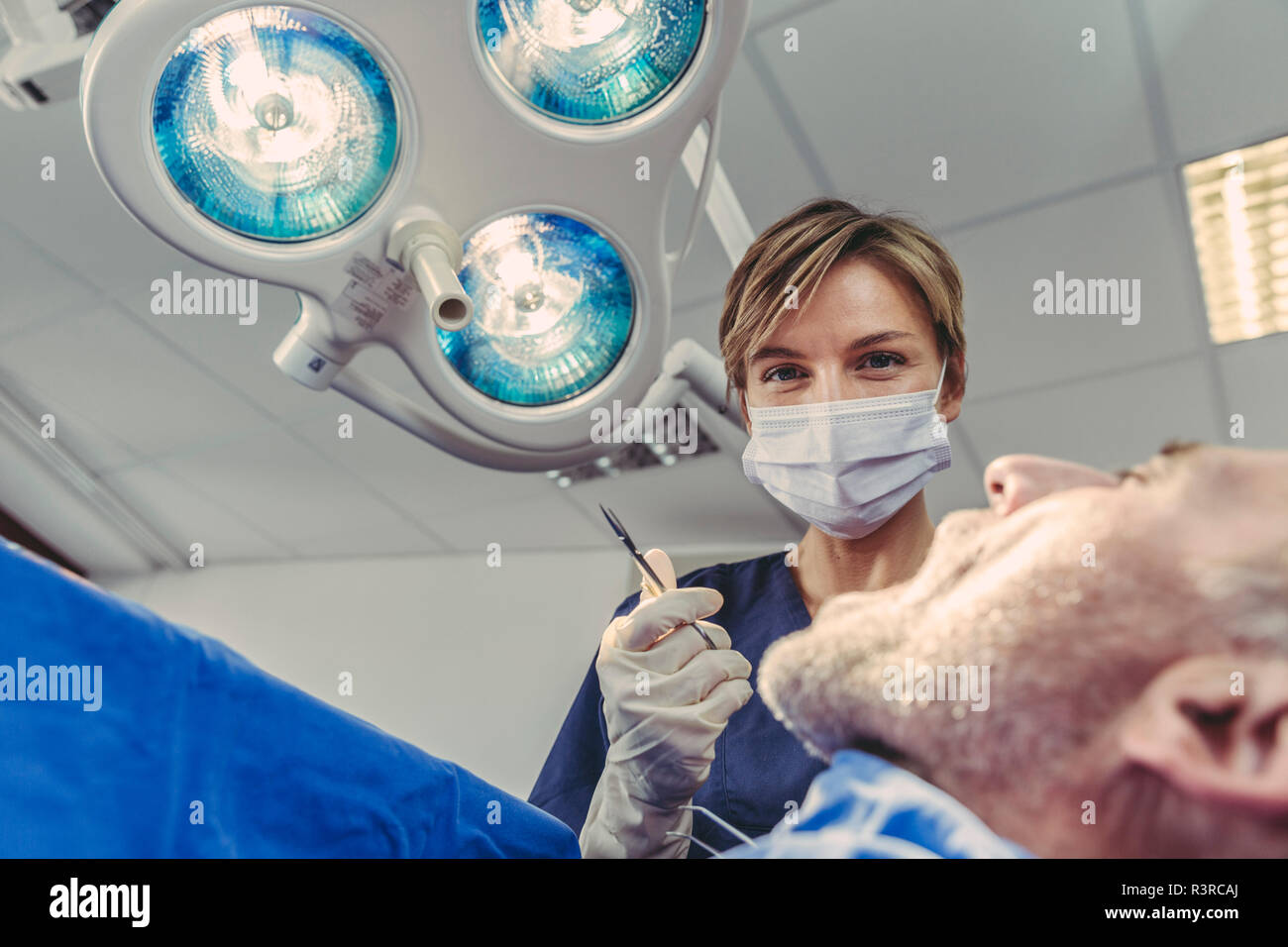 Dental surgeon during surgical procedure on a patient Stock Photo
