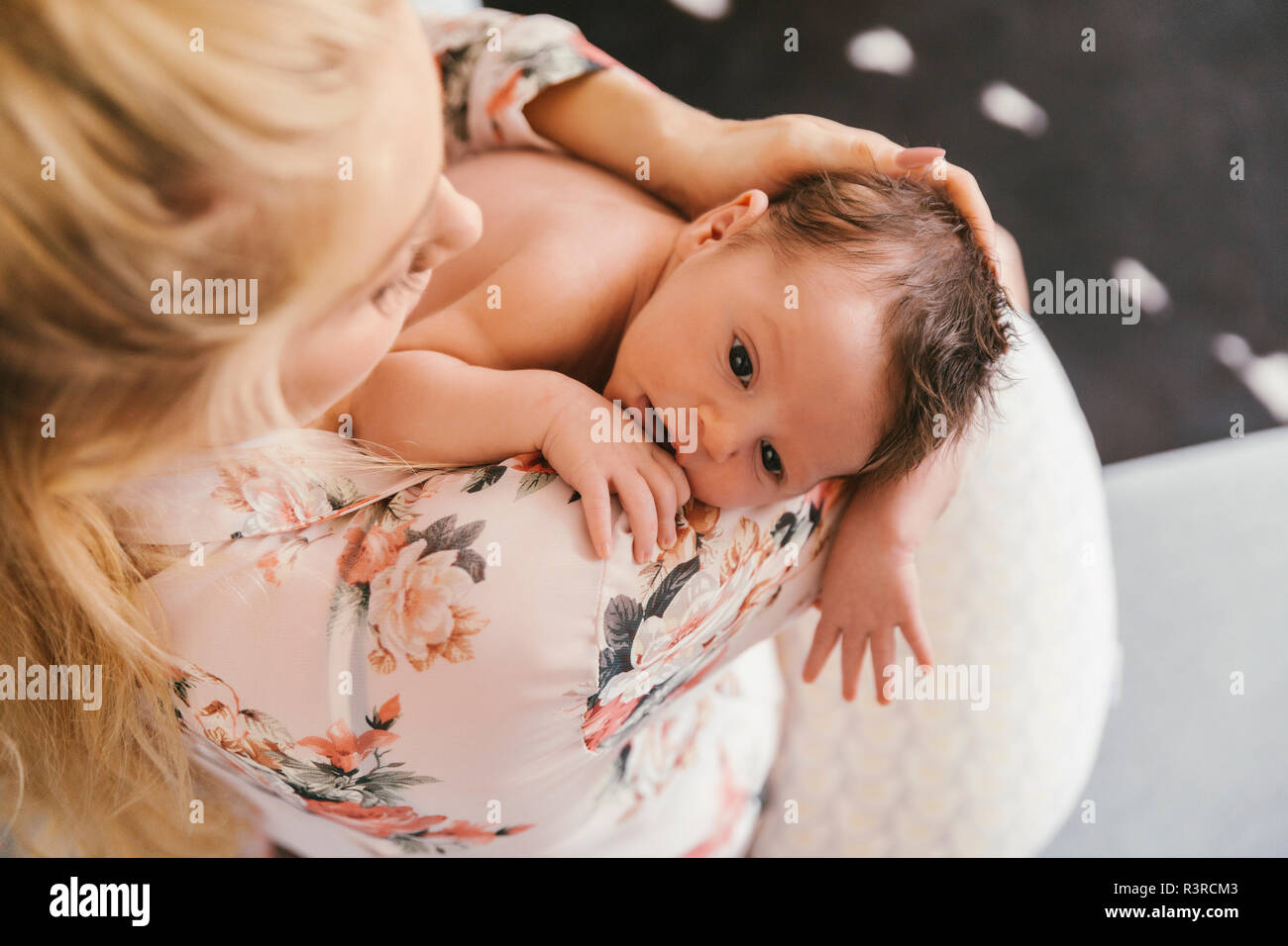 Mother holding her baby close to her shoulder Stock Photo