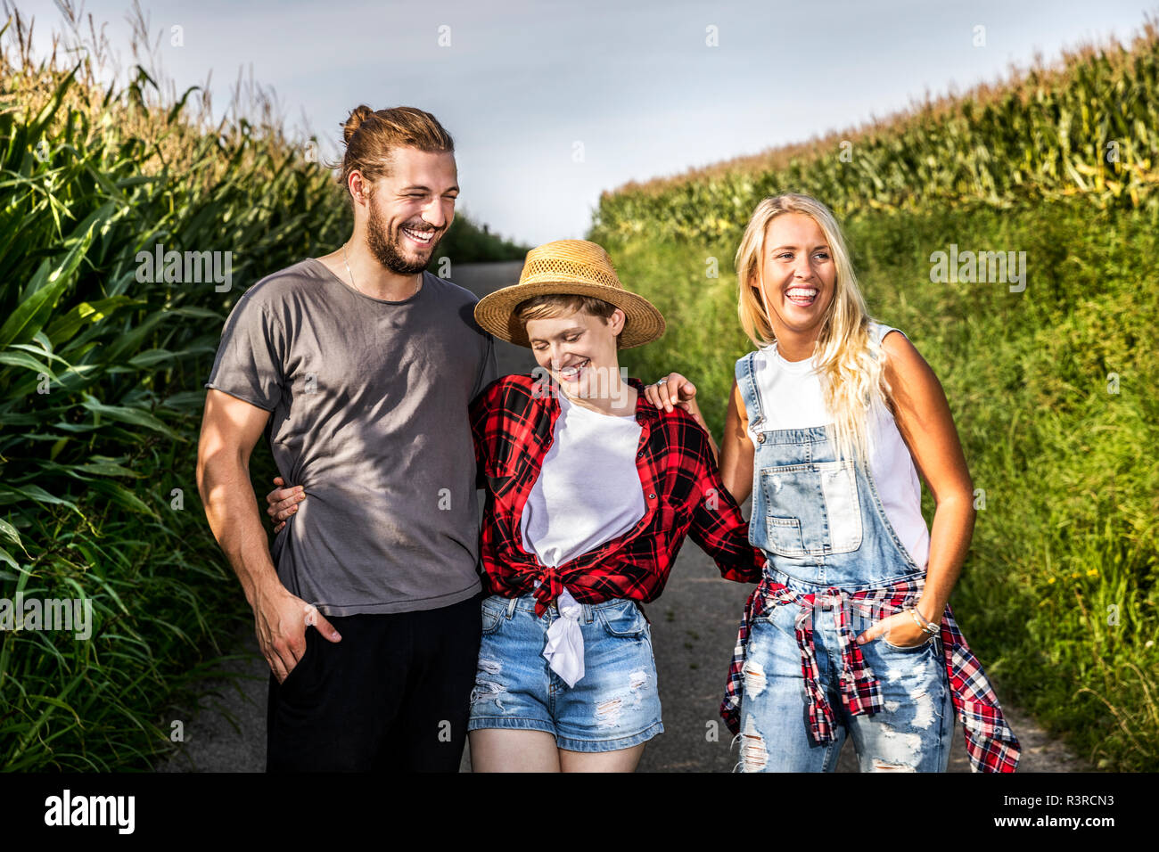 Happy friends on country lane at a cornfield Stock Photo - Alamy