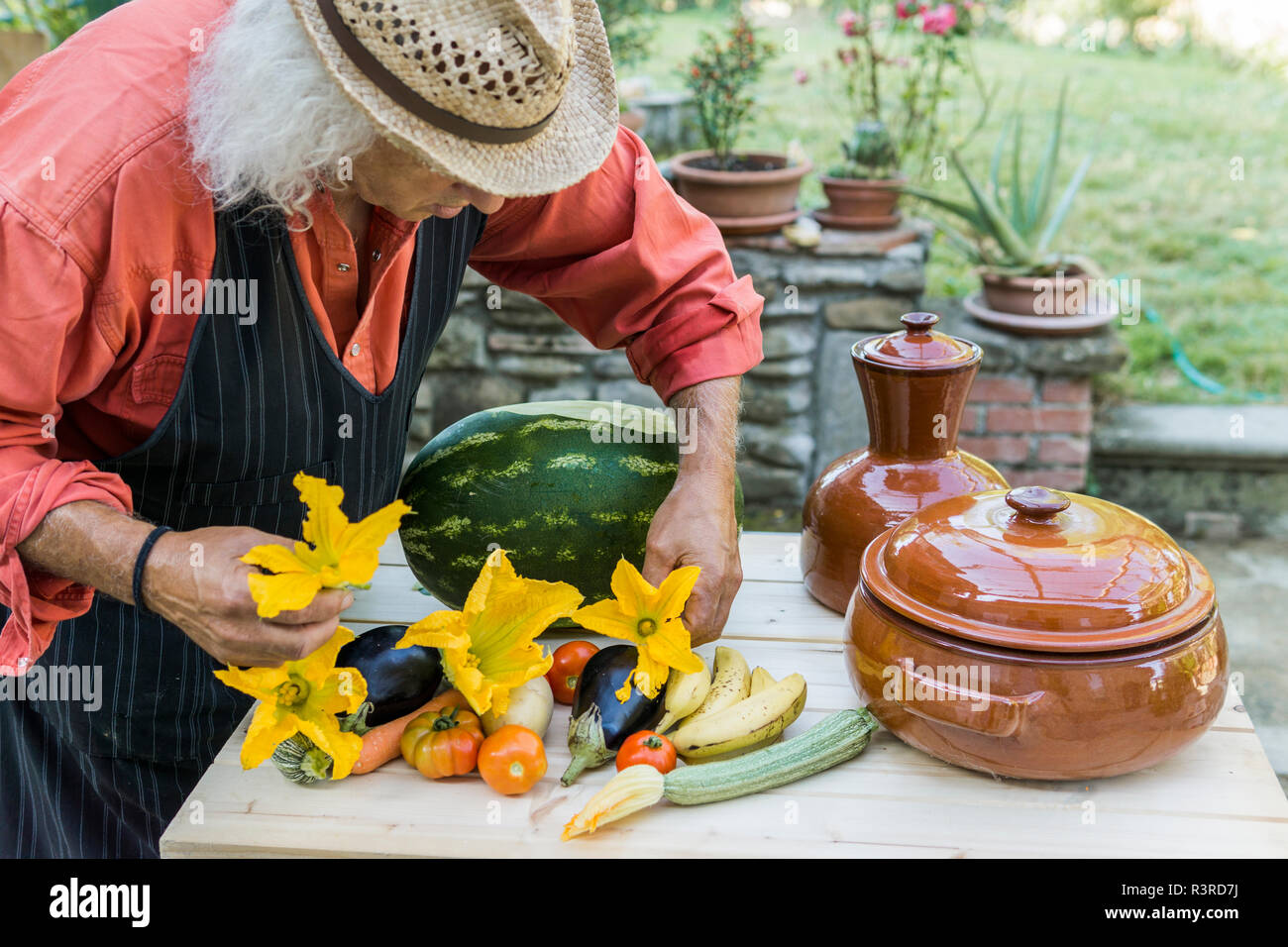 Senior Man Decorating A Table With Fruits And Vegetables Stock