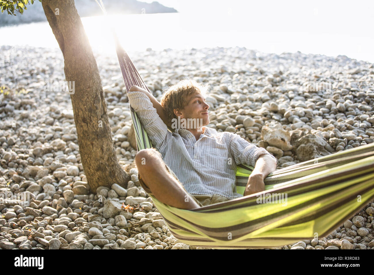 Croatia, Cres Island, content man relaxing in hammock on the beach Stock Photo