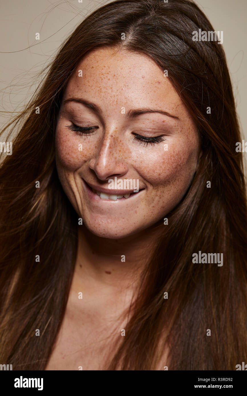 Portrait of freckled young woman looking down Stock Photo