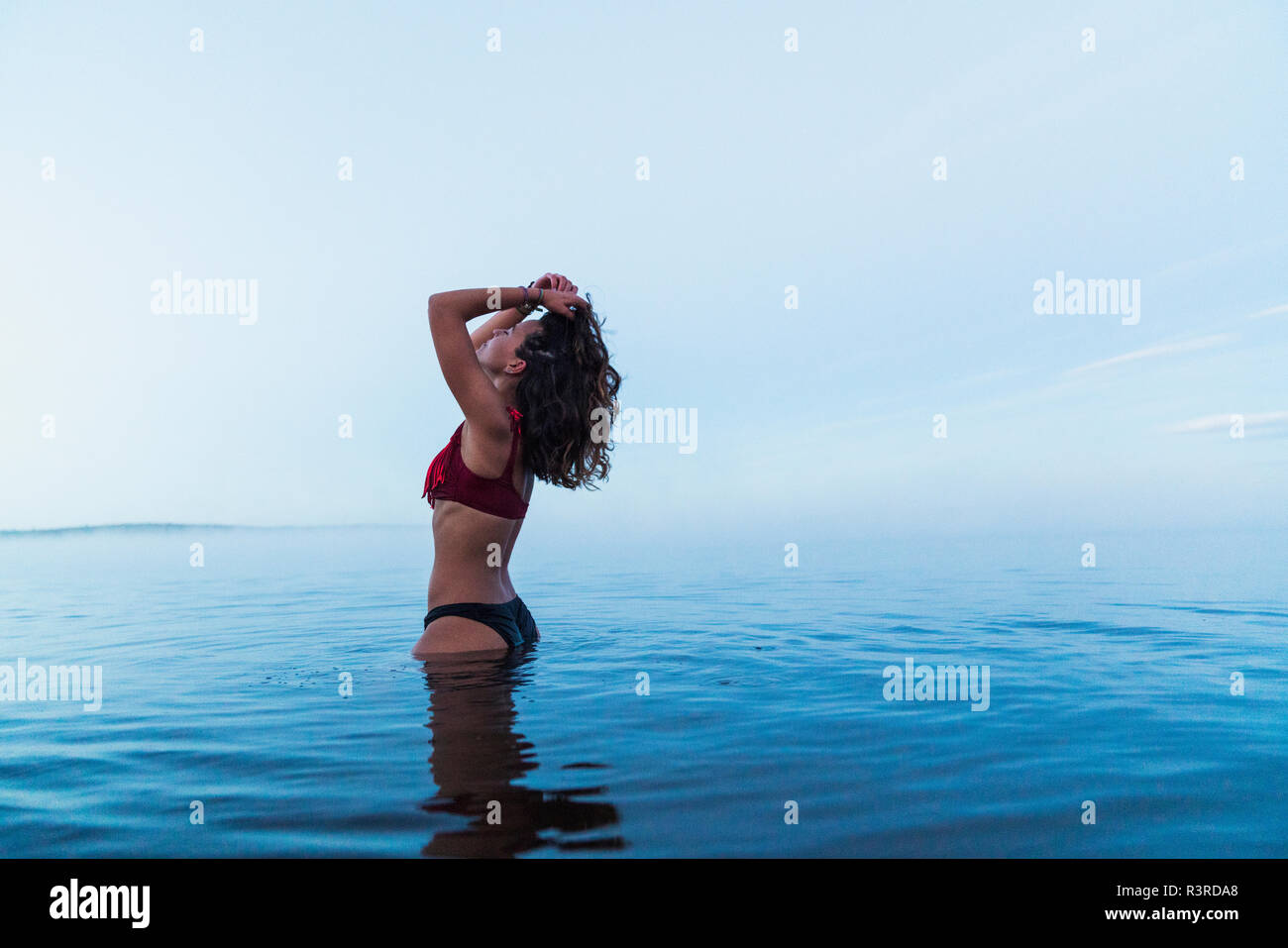Woman wearing bikini, standing in water of a lake Stock Photo