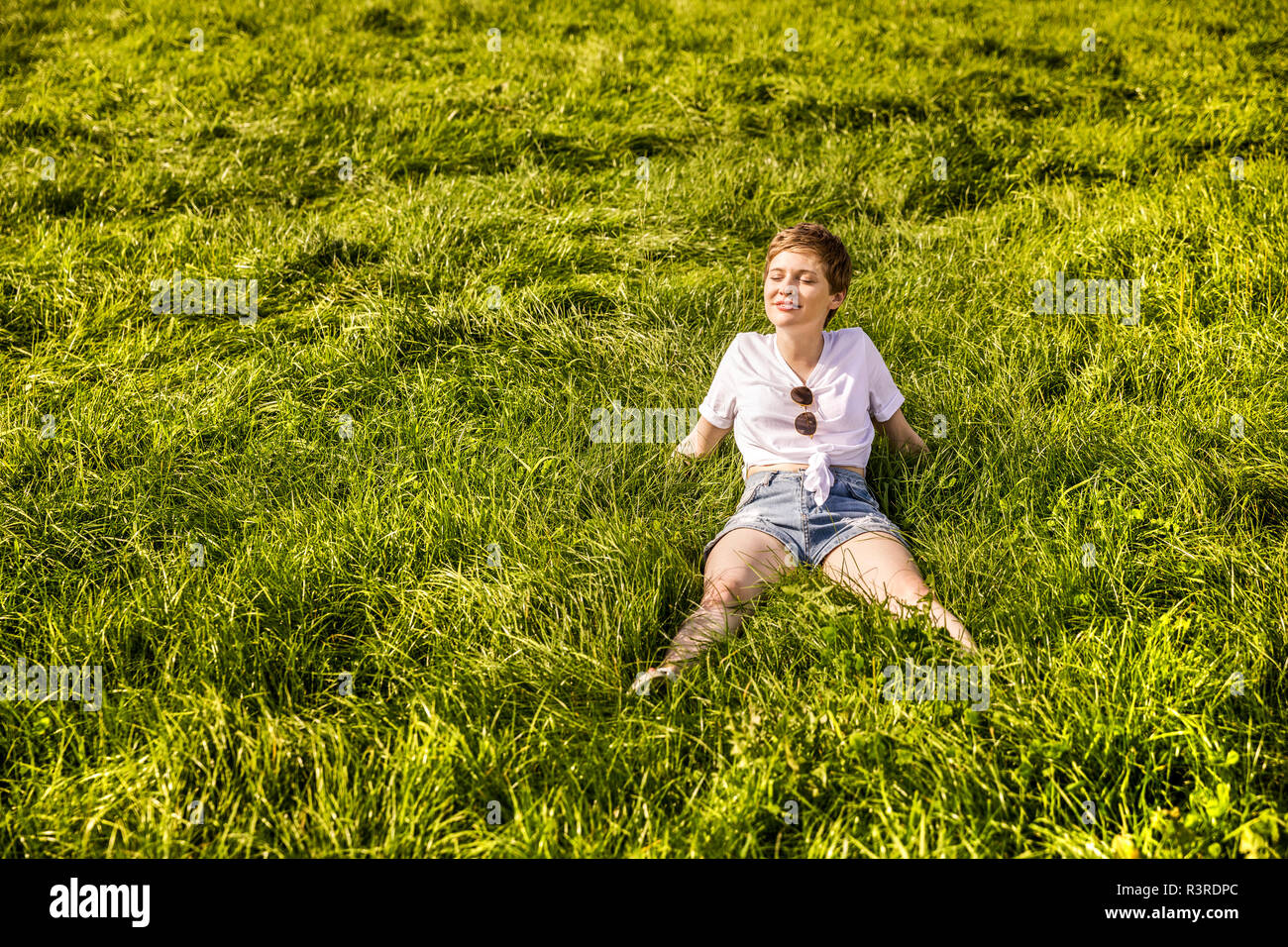 Woman in field enjoying sunlight Stock Photo