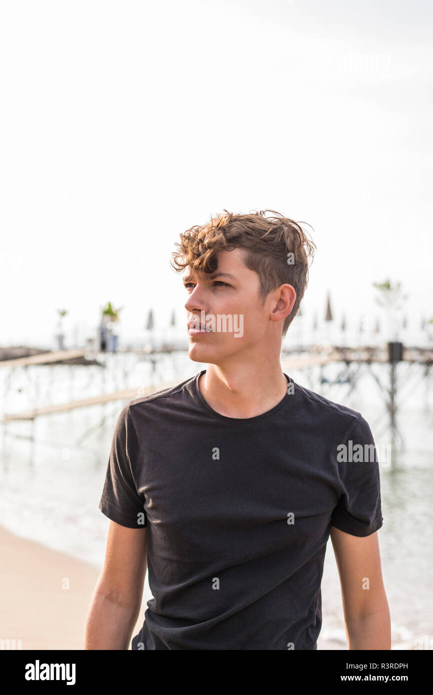 Portrait of young man on the beach watching something Stock Photo