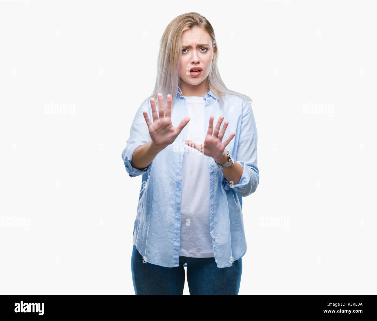 Young blonde woman over isolated background afraid and terrified with fear expression stop gesture with hands, shouting in shock. Panic concept. Stock Photo