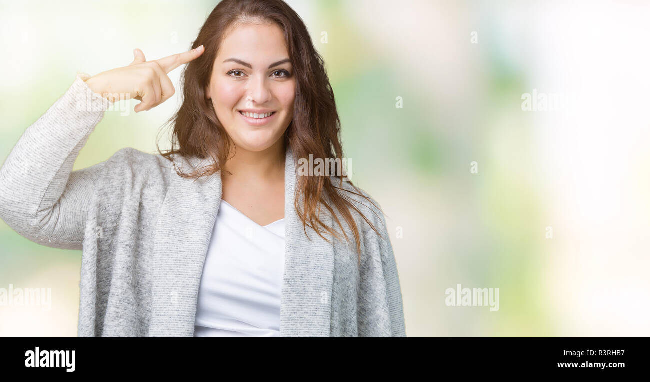 Beautiful plus size young woman wearing winter jacket over isolated background Smiling pointing to head with one finger, great idea or thought, good m Stock Photo