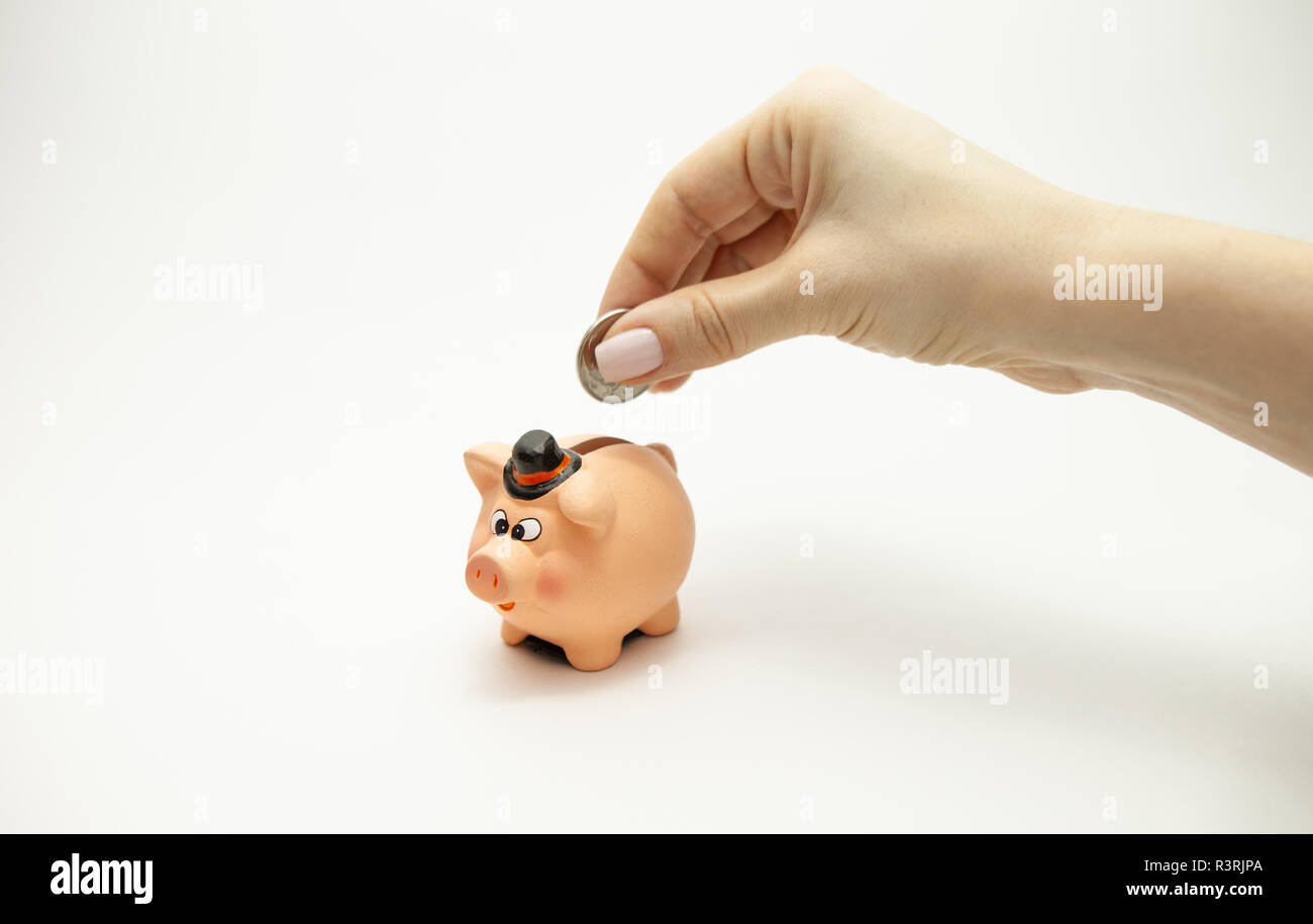 Woman hand putting coin into piggy bank. Saving money wealth and ...