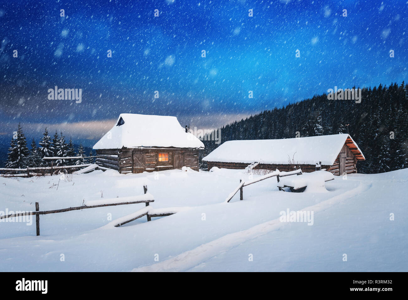 Fantastic winter landscape with wooden house in snowy mountains. Christmas holiday concept. Carpathians mountain, Ukraine, Europe Stock Photo