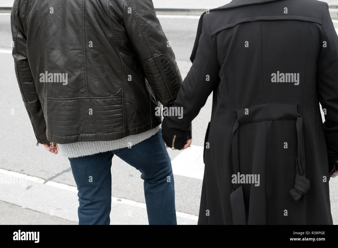 couple holding hands on street Stock Photo
