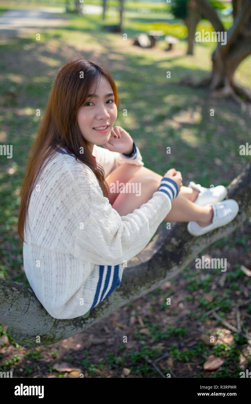 toothy smiling face happiness emotion of asian younger woman relaxing in park Stock Photo