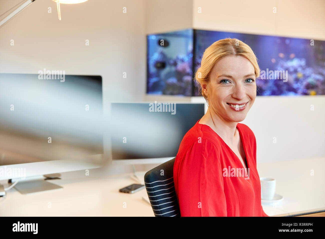 Woman sitting at office desk hi-res stock photography and images - Alamy