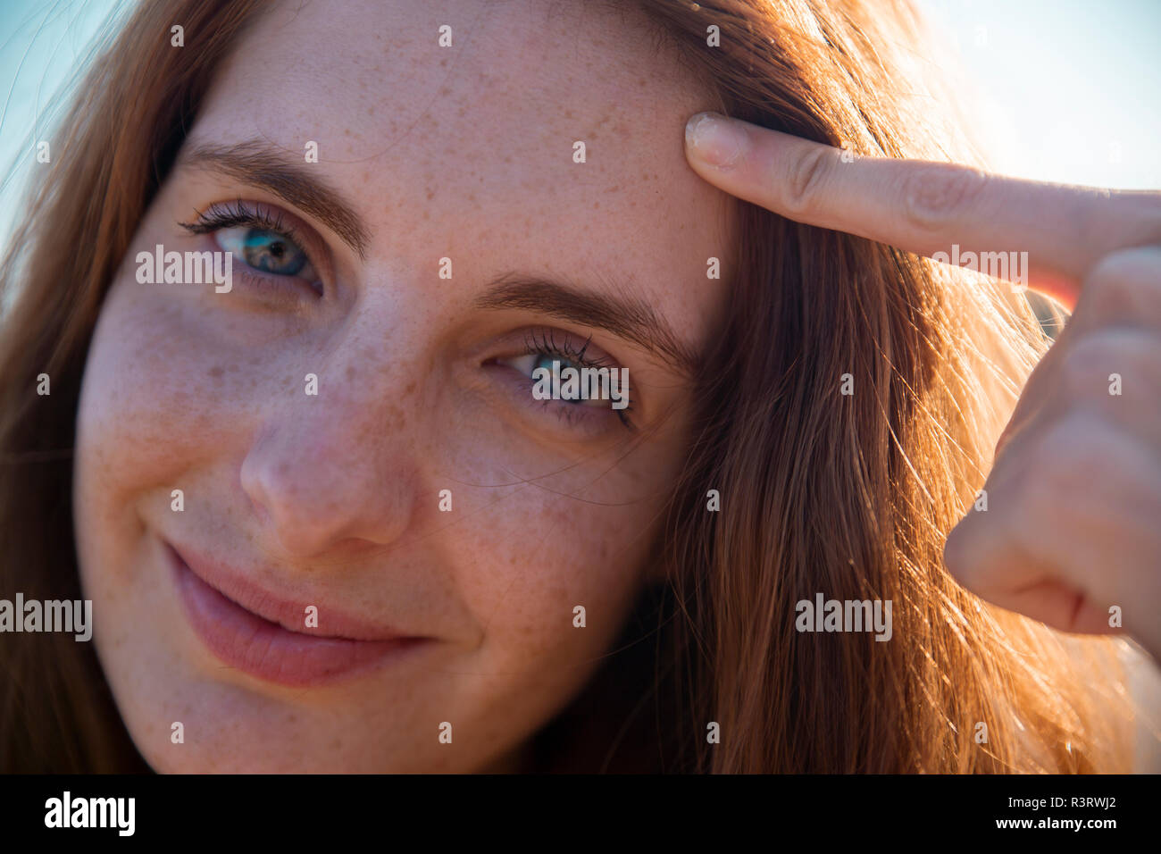 Portrait of smiling young woman with freckles Stock Photo