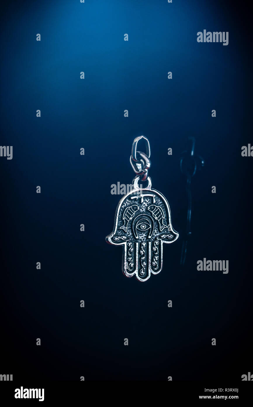 The Hamsa Hand - a middle Eastern/ Jewish amulet symbolising the hand of god against blue background Stock Photo