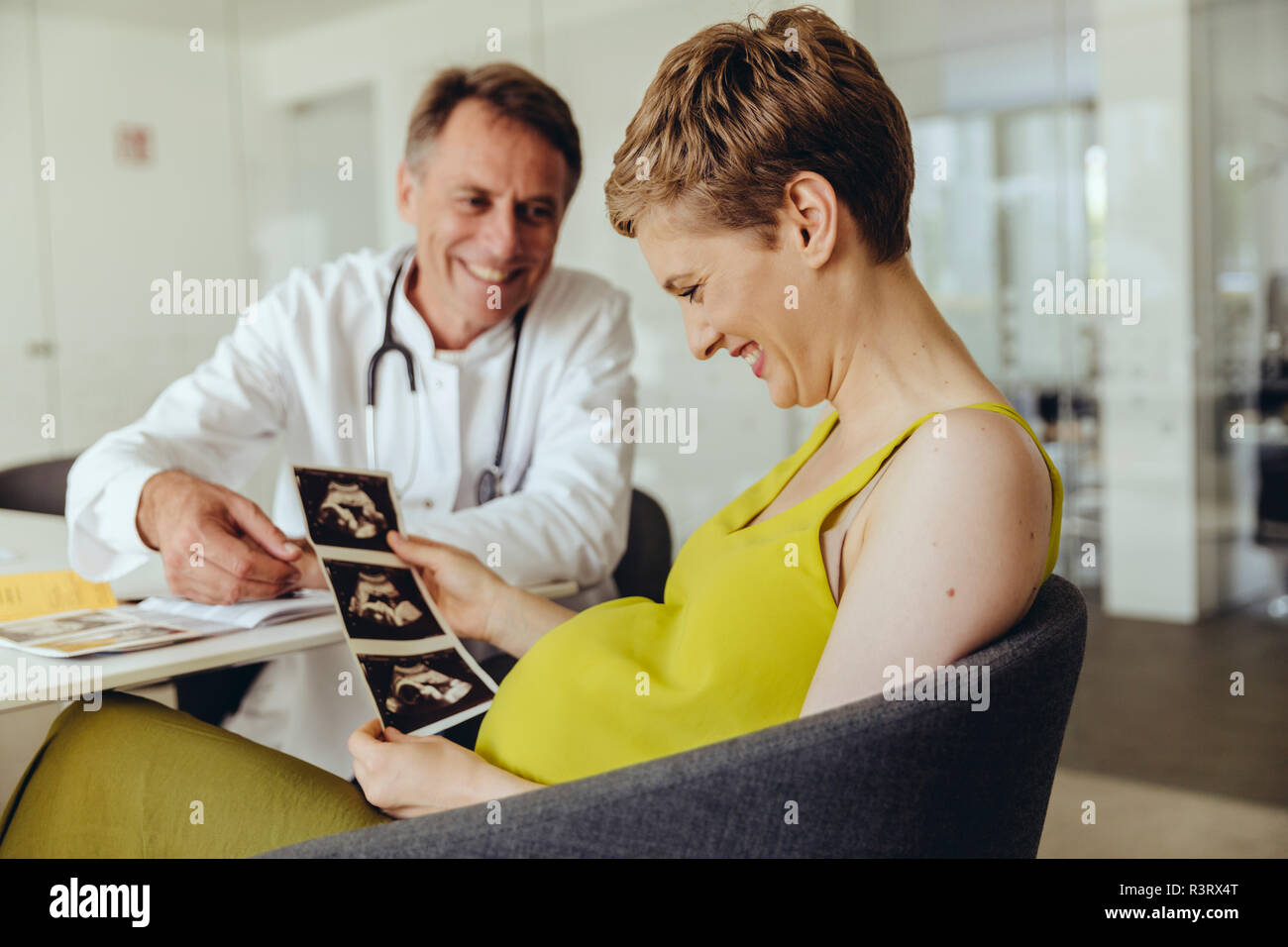 Pregnant woman discussing ultrasonic scans with her doctor Stock Photo
