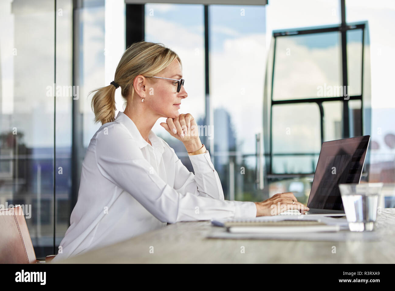 Businesswoman working in office, using laptop Stock Photo