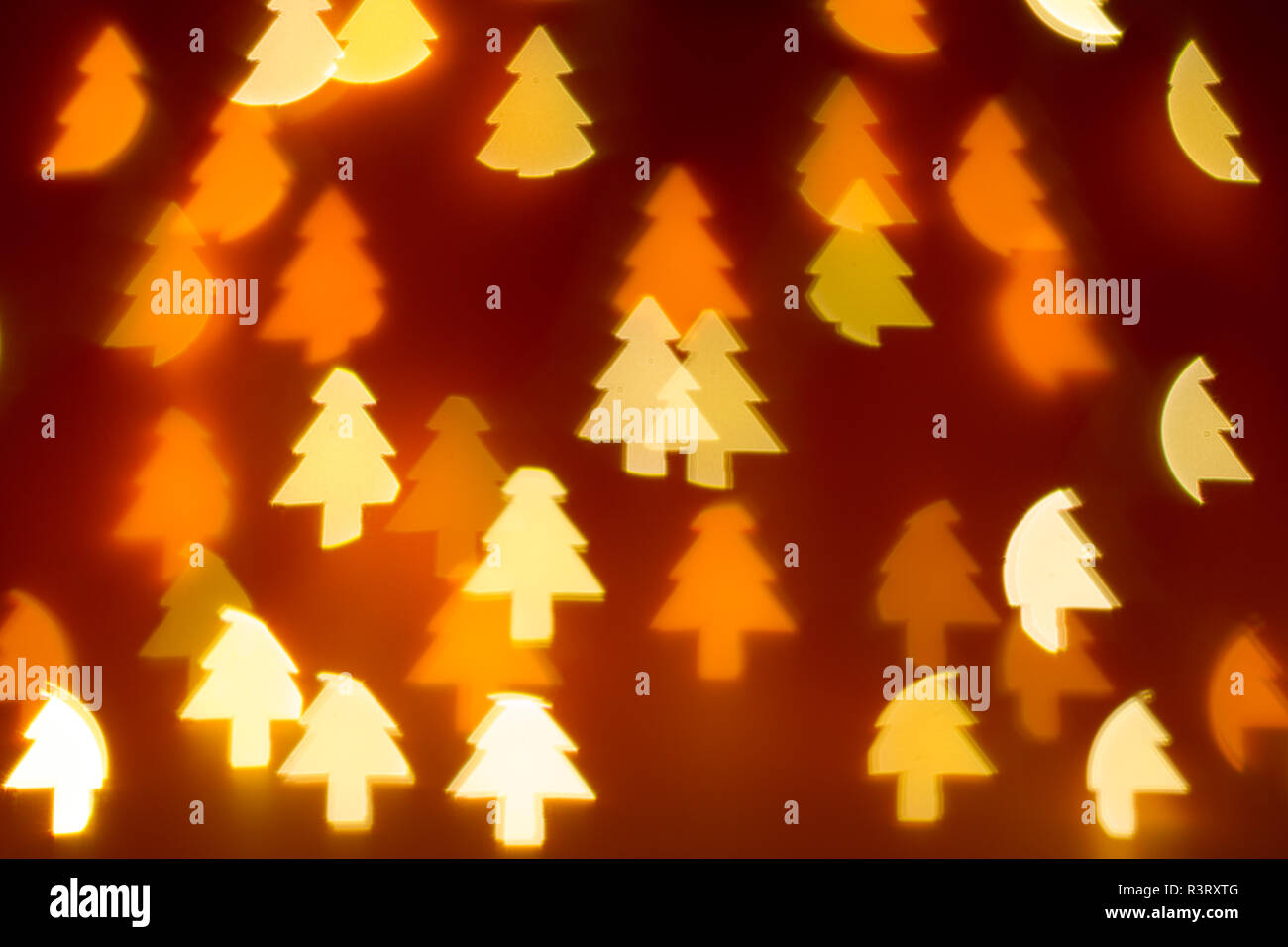 Bokeh Christmas tree shaped lights on dark red background Stock Photo