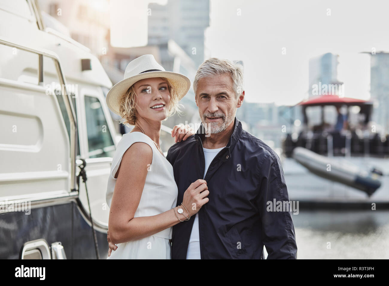 Older man and young woman at a marina next to a yacht Stock Photo