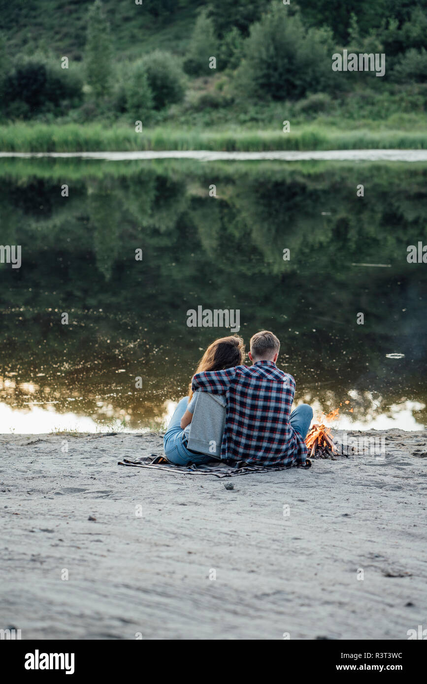 Romantic couple sitting at the riverside Stock Photo - Alamy