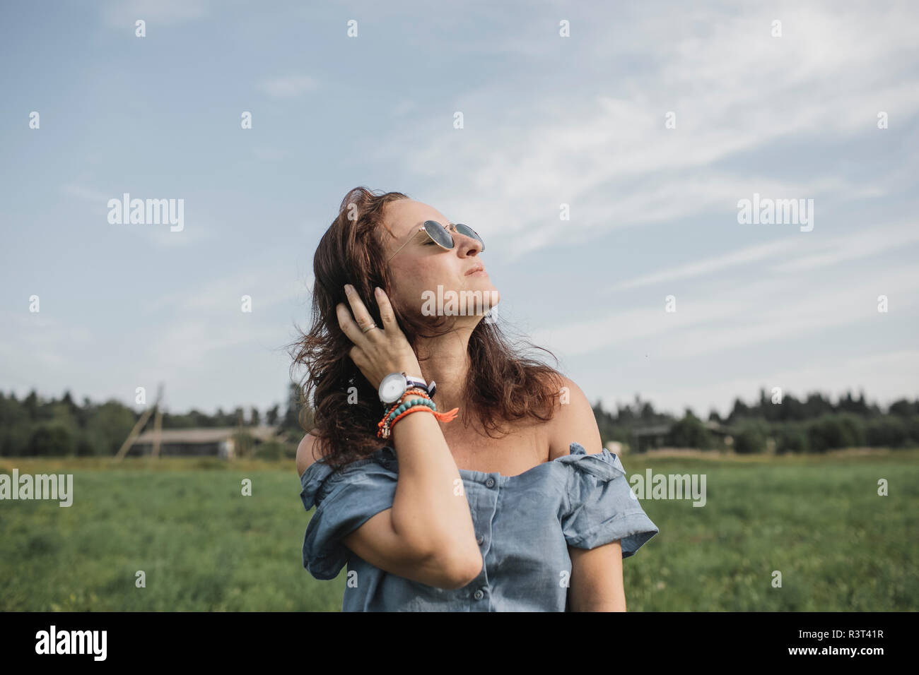 Relaxed woman on a rural field Stock Photo
