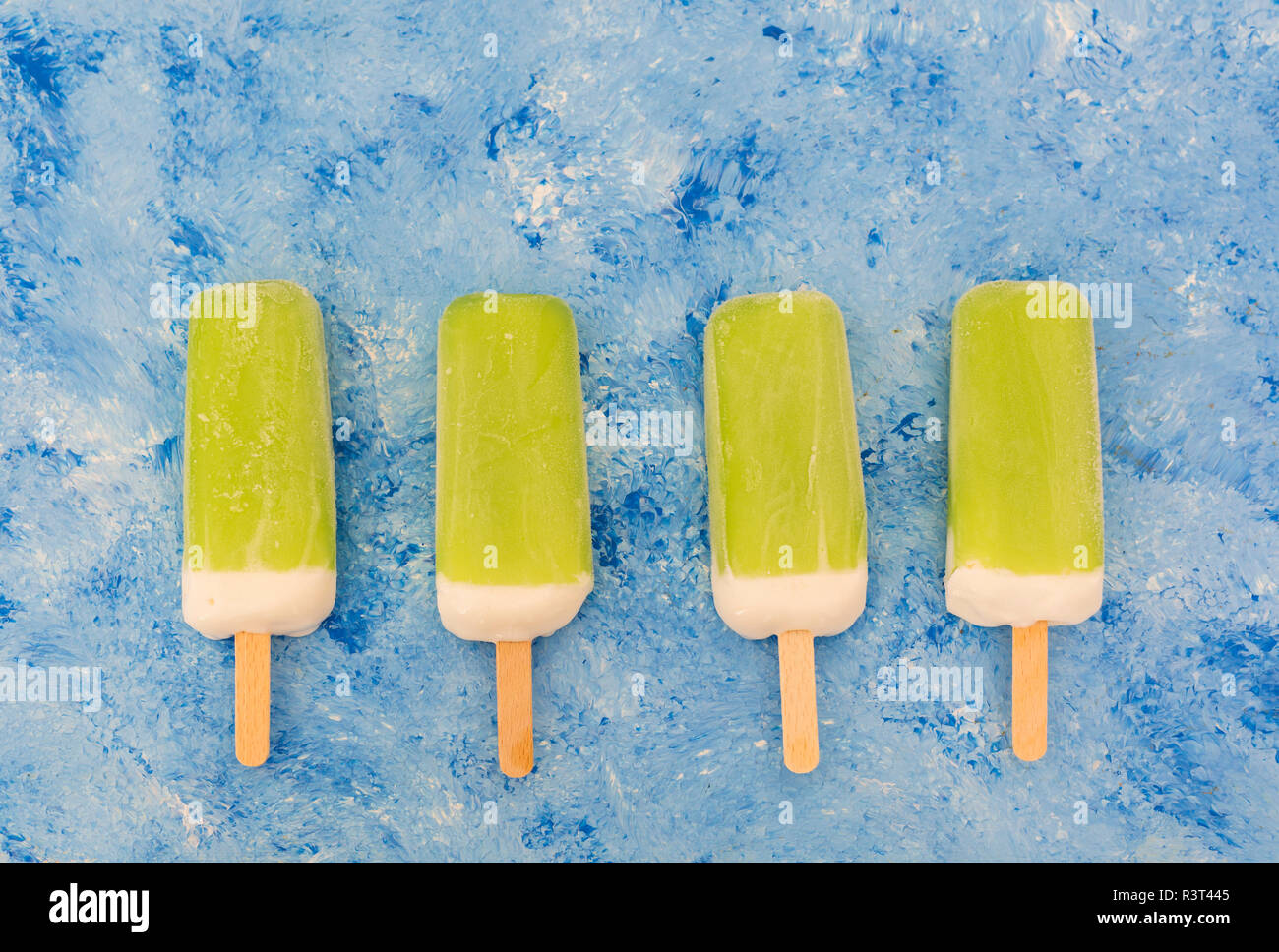 Row of four lime mint popsicles on light blue background Stock Photo Alamy