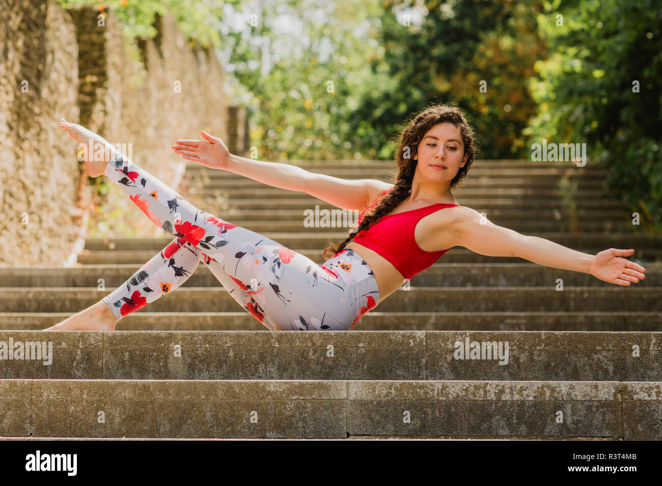 Young woman practicing Pilates in an urban park Stock Photo