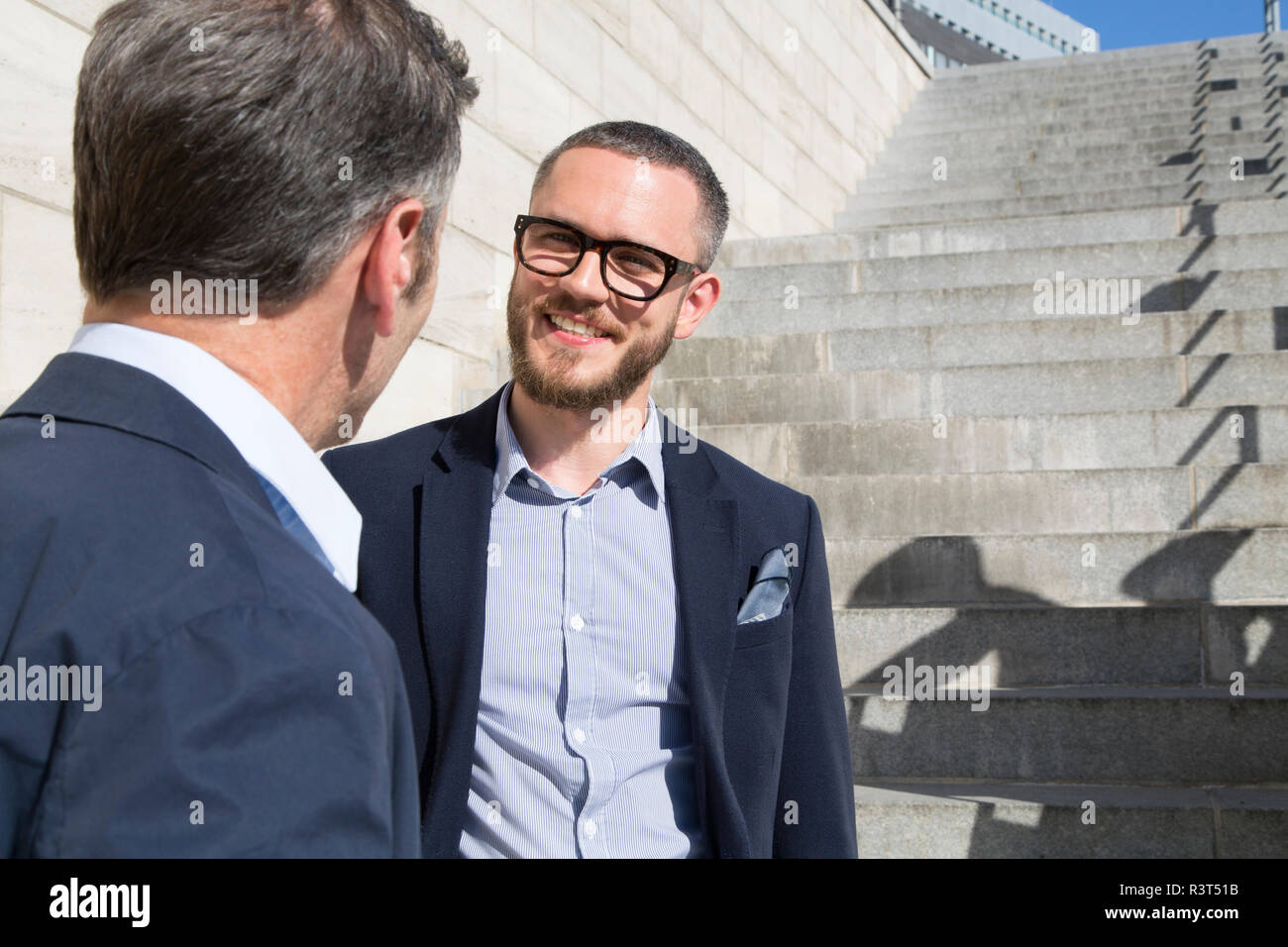 Two businessmen talking at stairs outdoors Stock Photo