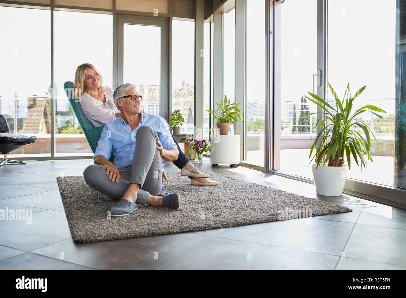 Mature couple relaxing at home looking out of window Stock Photo